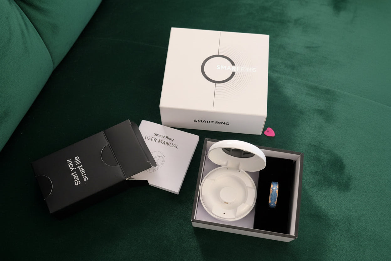 blue smart ring with case, guide and packaging boxes on a green sofa