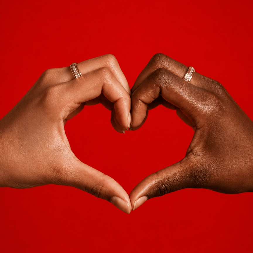 Two hands forming a heart shape against a solid red background, each wearing a stylish nala smart ring.